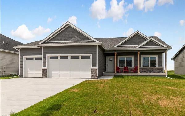 A gray house with a white garage door and a porch.