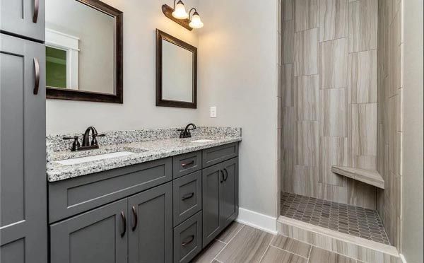 A bathroom with two sinks and a walk in shower.