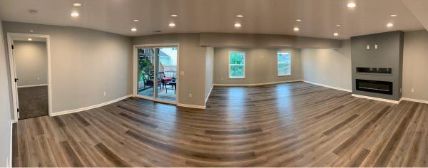 A large empty living room with hardwood floors and a fireplace.