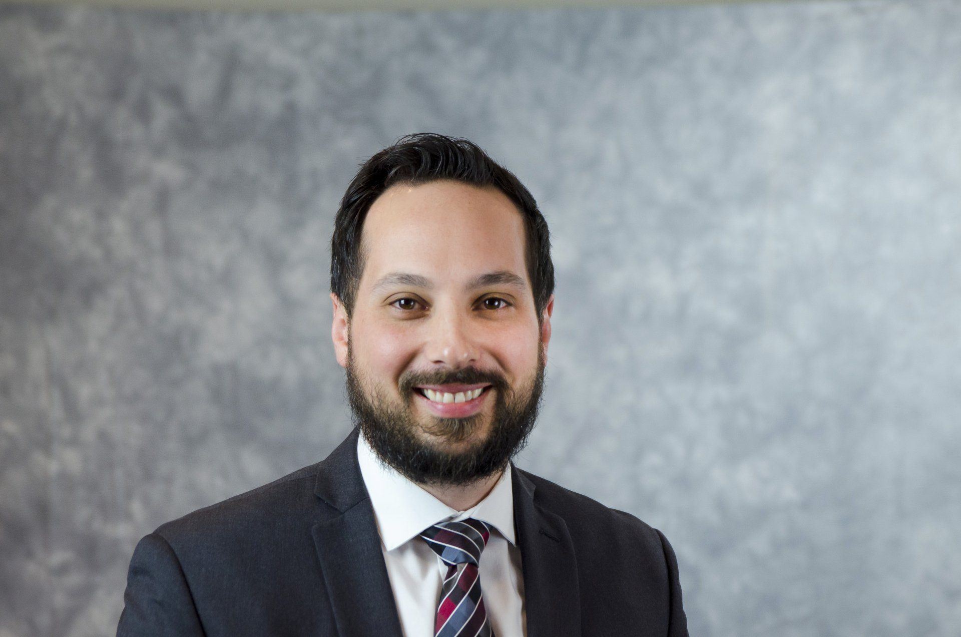 A man in a suit and tie is smiling for the camera.