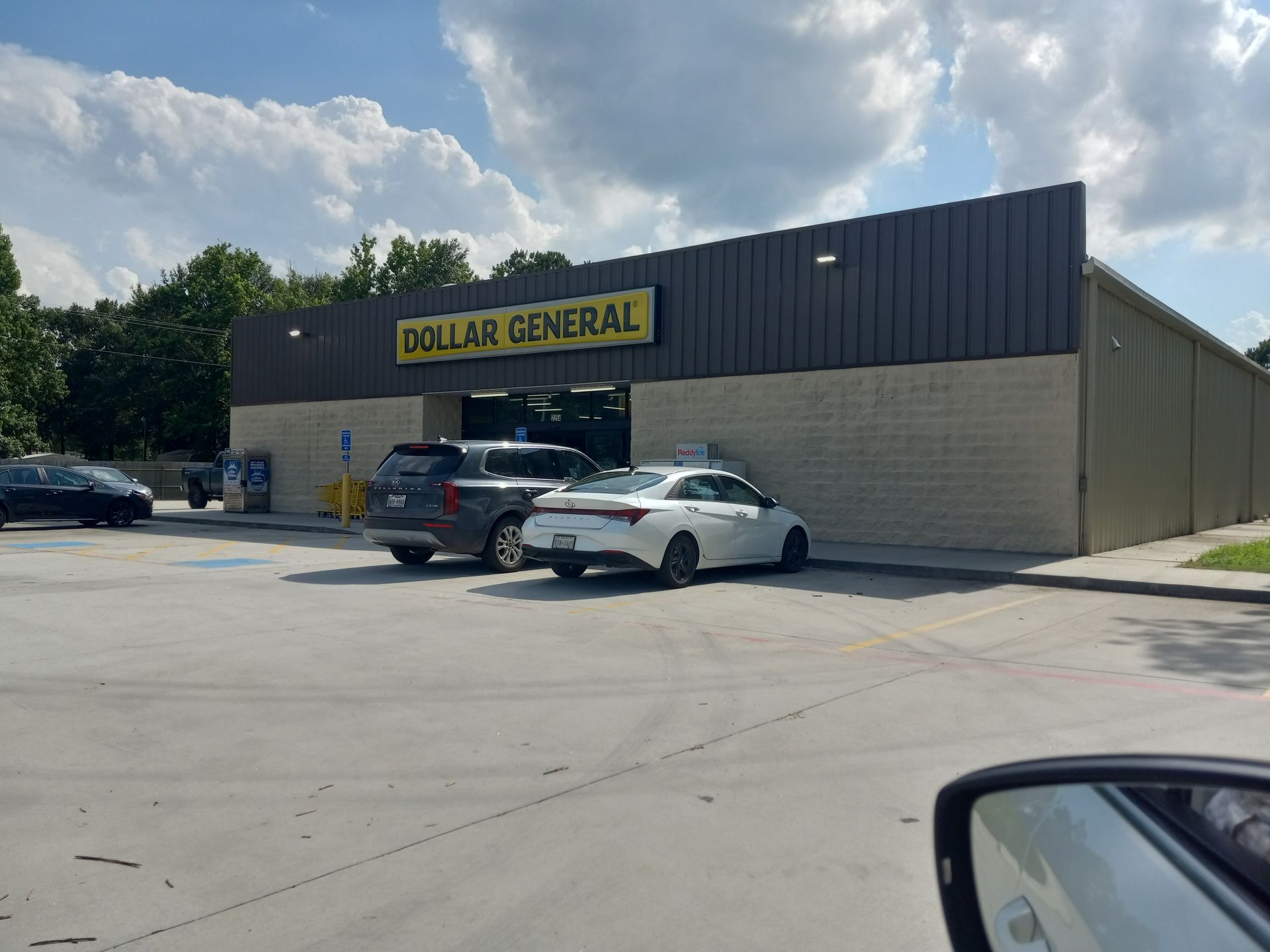 Dollar General store with cars parked outside on a sunny day.