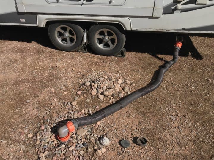 A hose is laying on the ground next to a trailer