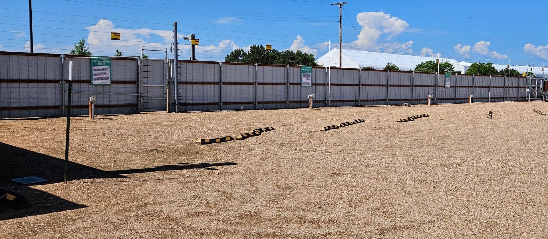 A large sandy area with a fence in the background.