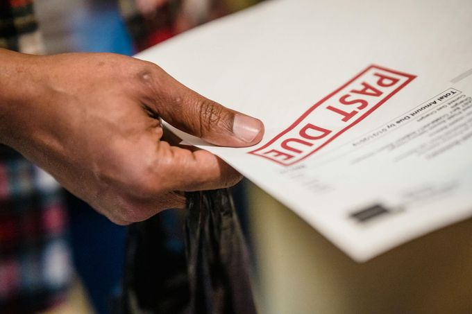 Close-up of a hand holding a white document stamped with the red words 