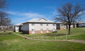 Photo showing a building in the middleground, with a slight-incline staircase leading up to it.