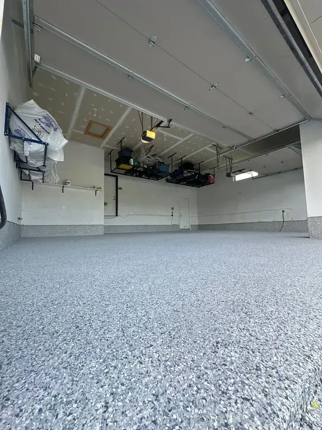A garage with a gray floor and white walls.