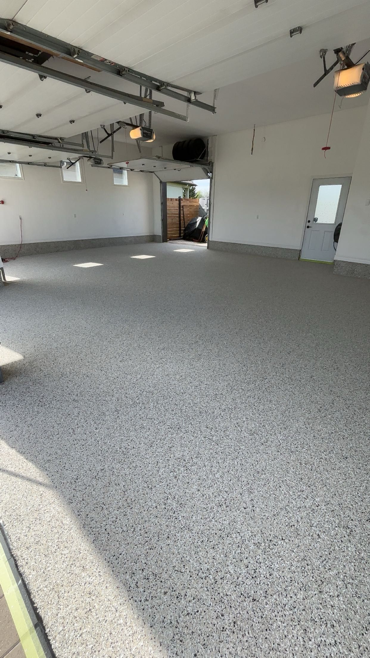 A large empty garage with a gray floor and white walls.