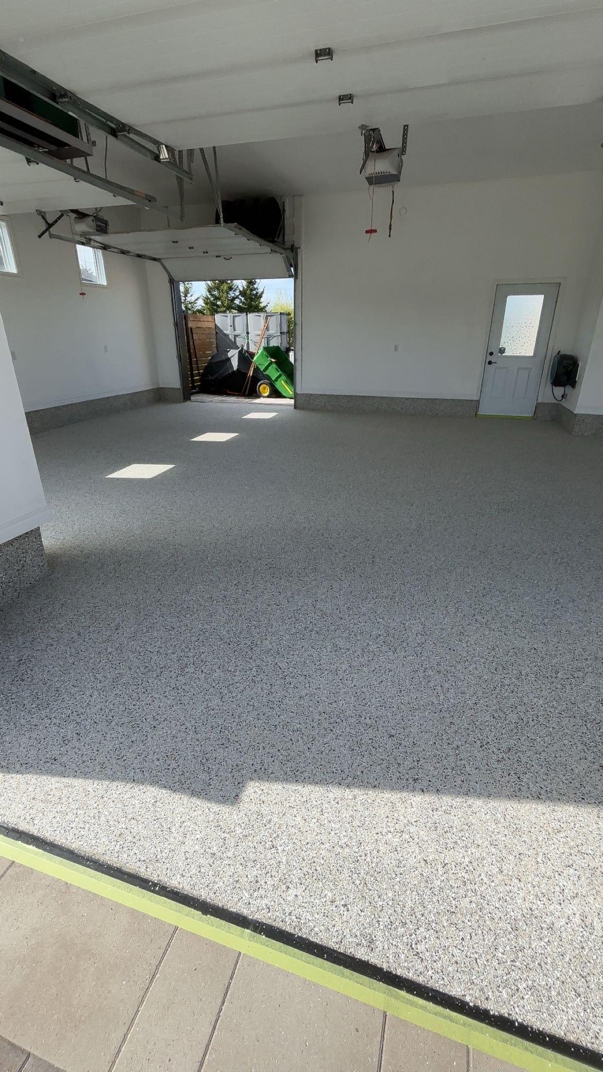 A garage with a concrete floor and a car parked in it.