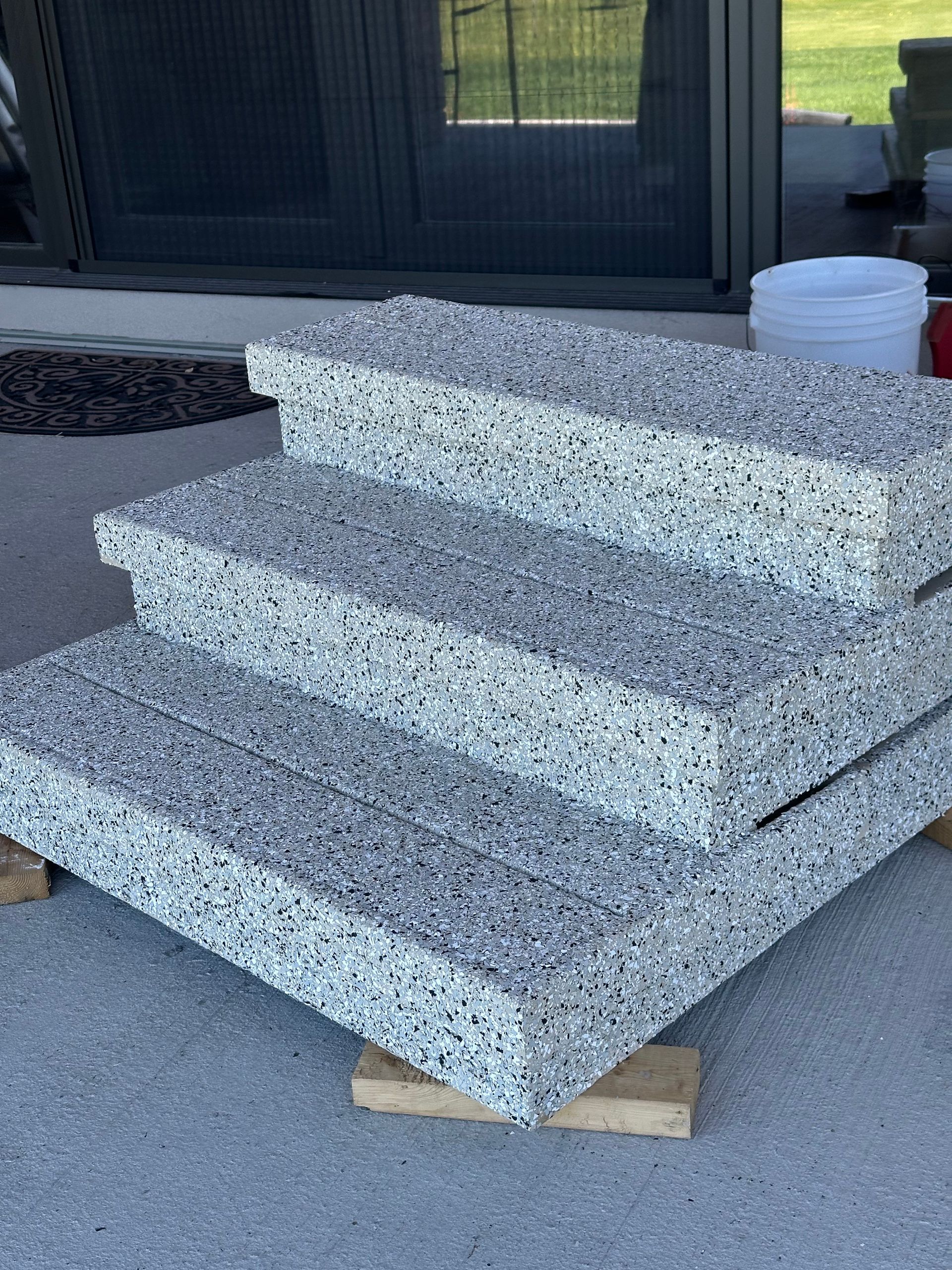A stack of concrete steps sitting on top of each other on a concrete surface.