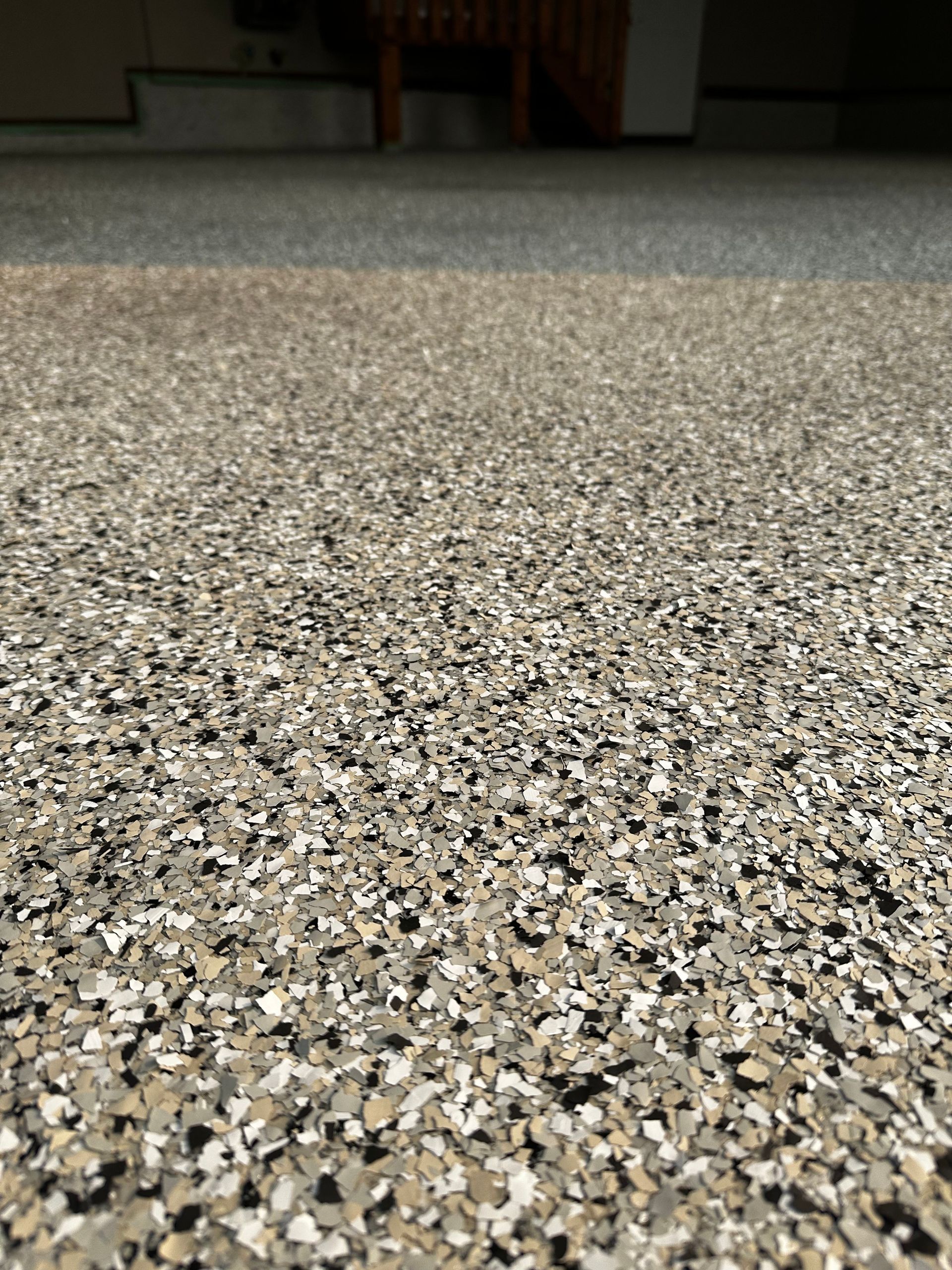 A close up of a garage floor with a lot of small stones on it.