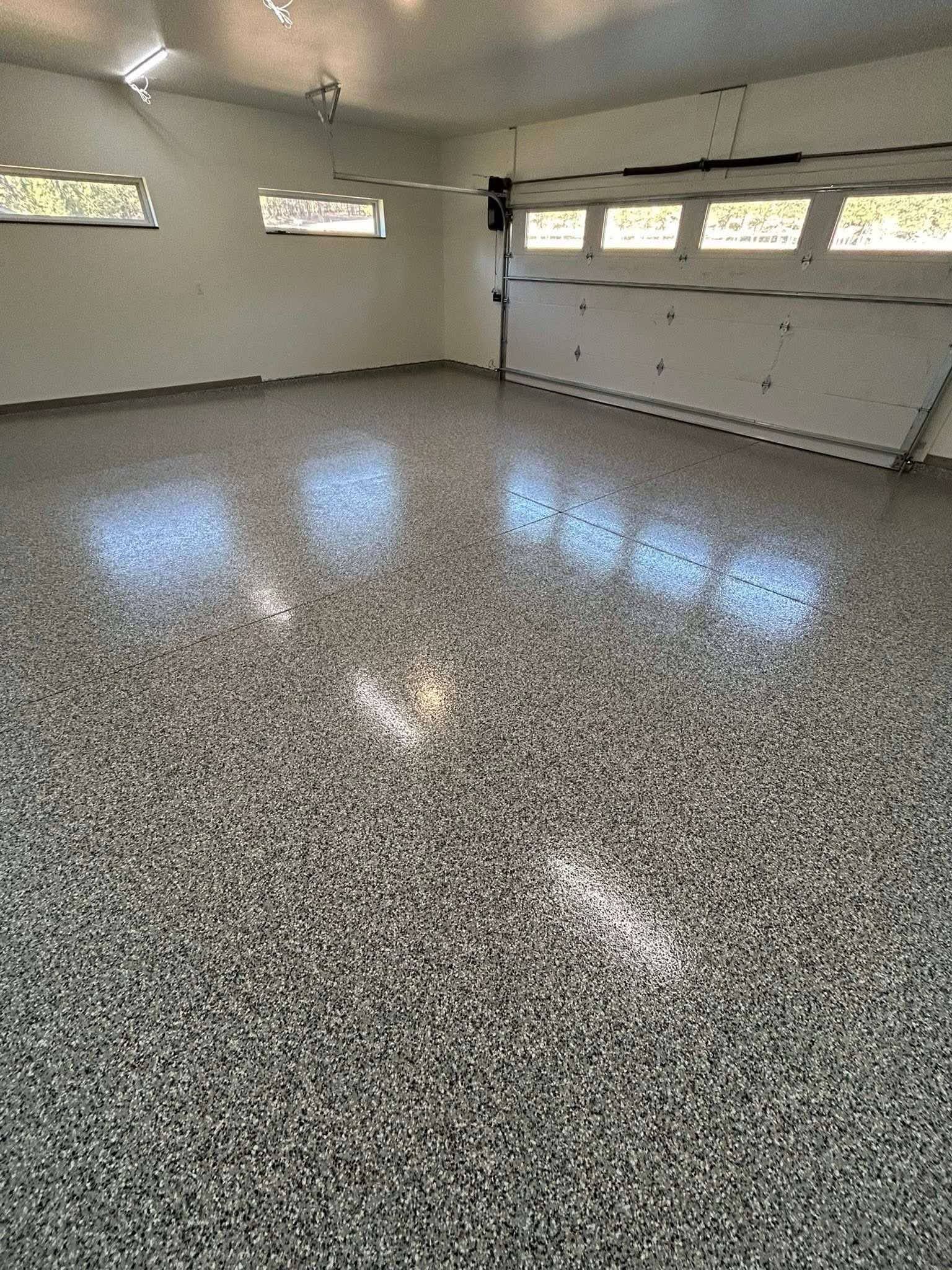 A garage with a gray floor and a garage door.