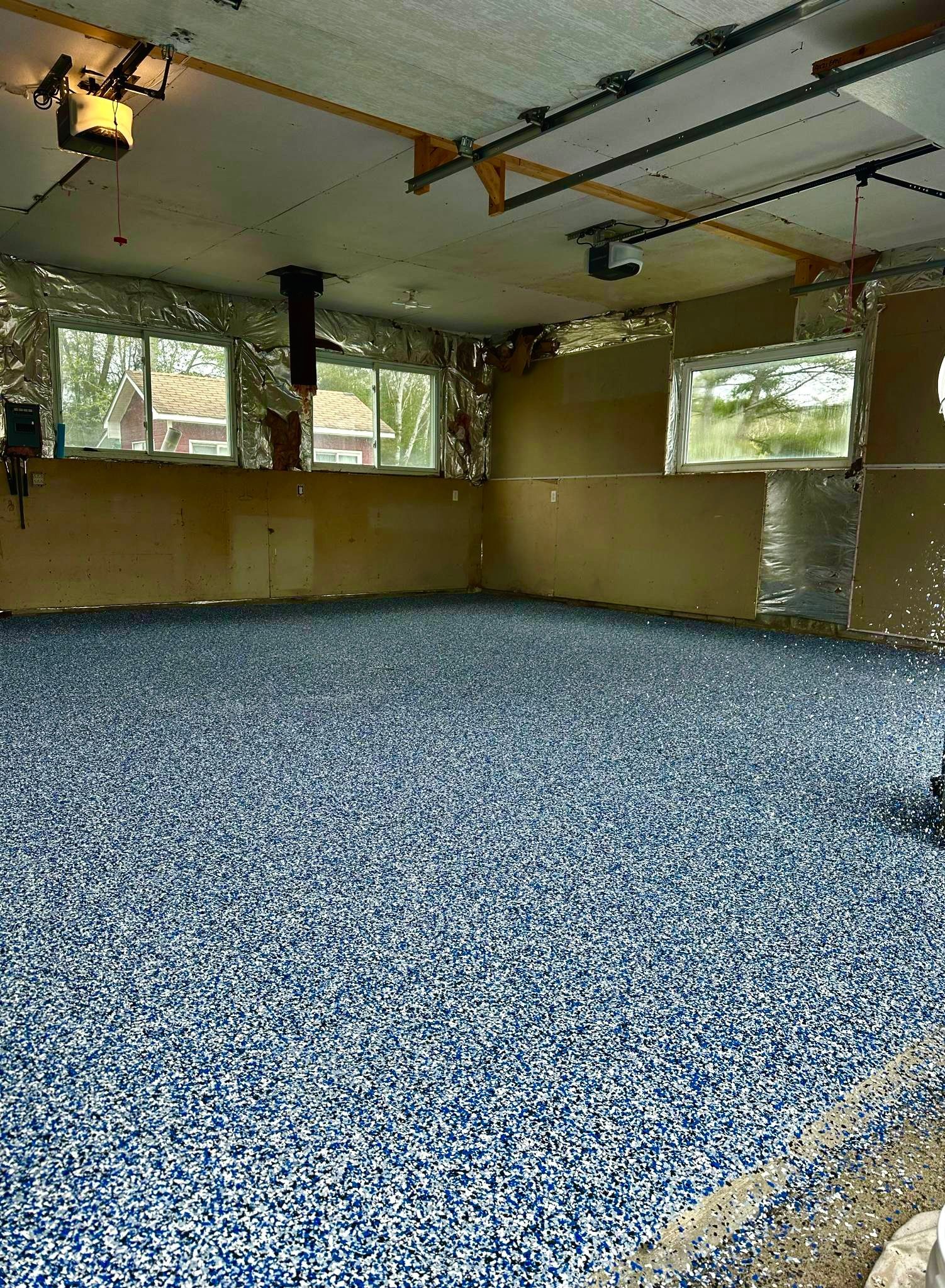 A garage with a lot of blue gravel on the floor.