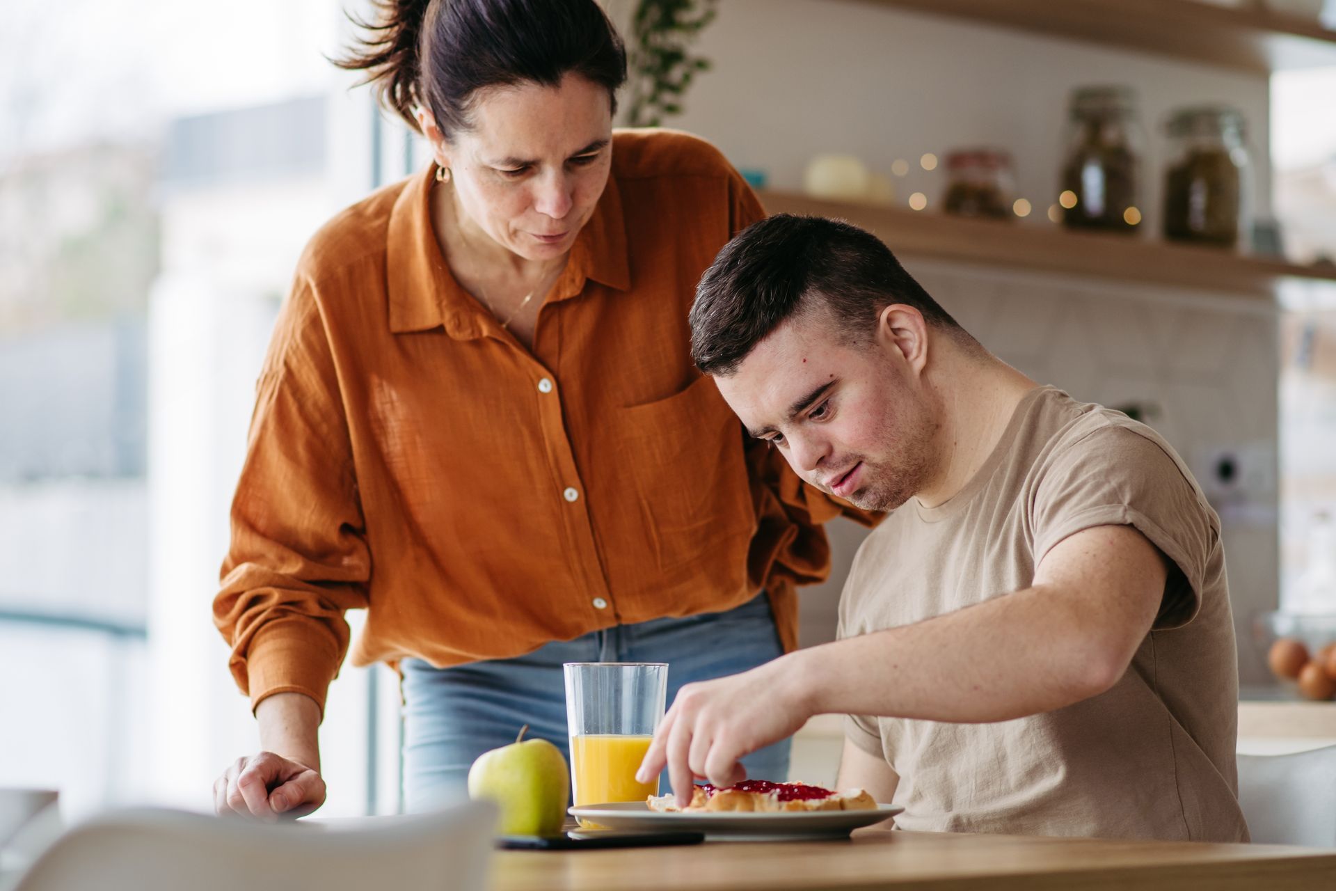 Woman Watches As A Man With Down Syndrome Spreads Jam On Toast — Side By Side Support Services Casino in Casino, NSW