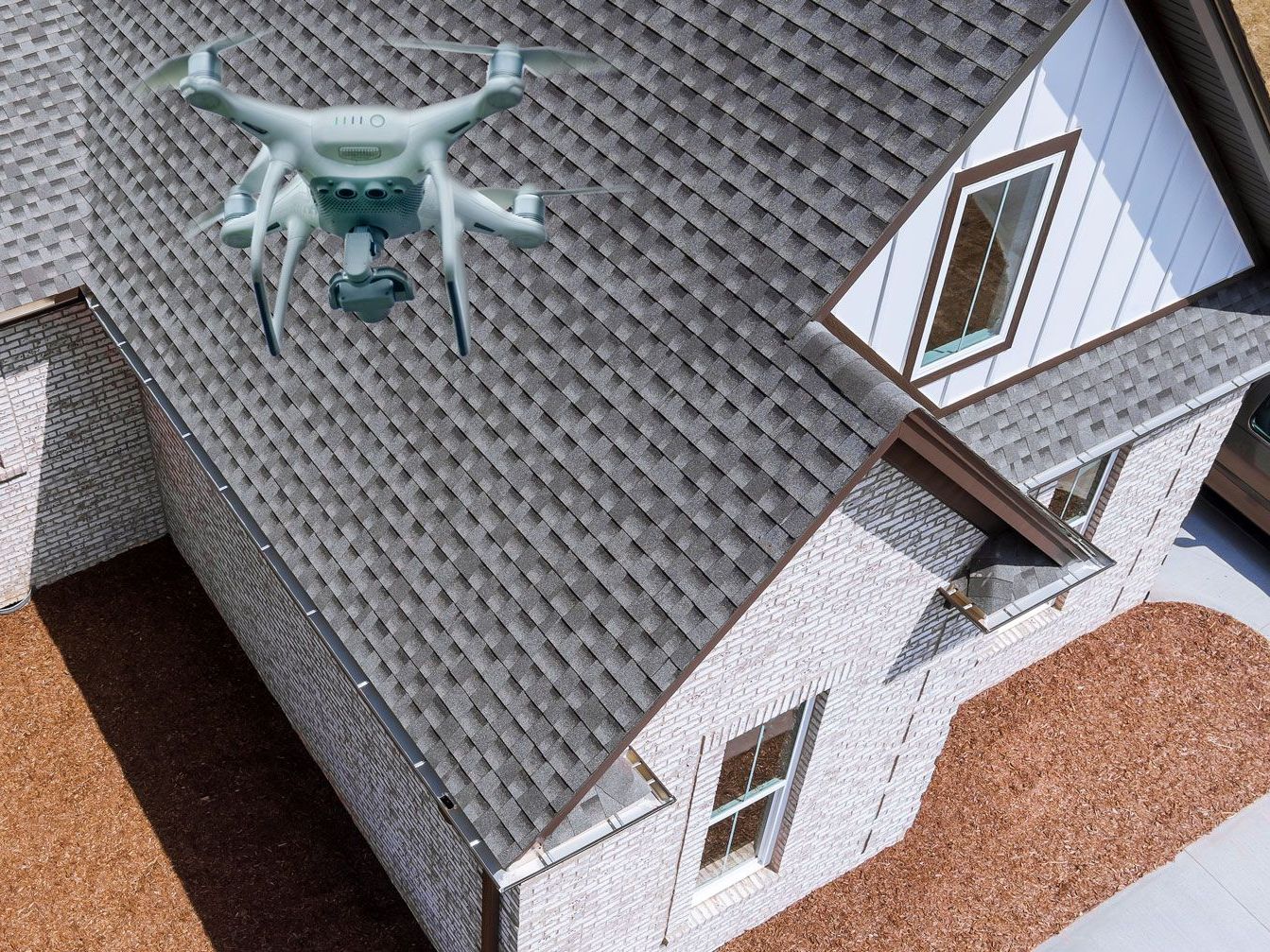 A drone is flying over a roof in a residential area.