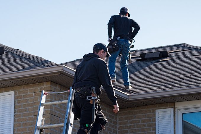 A man is working on the roof of a house.