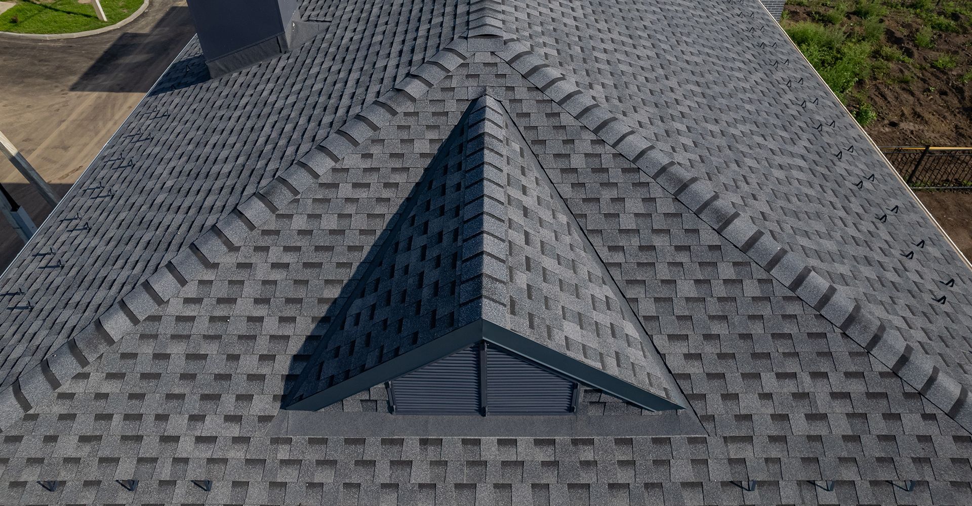 A drone is flying over a roof in a residential area.