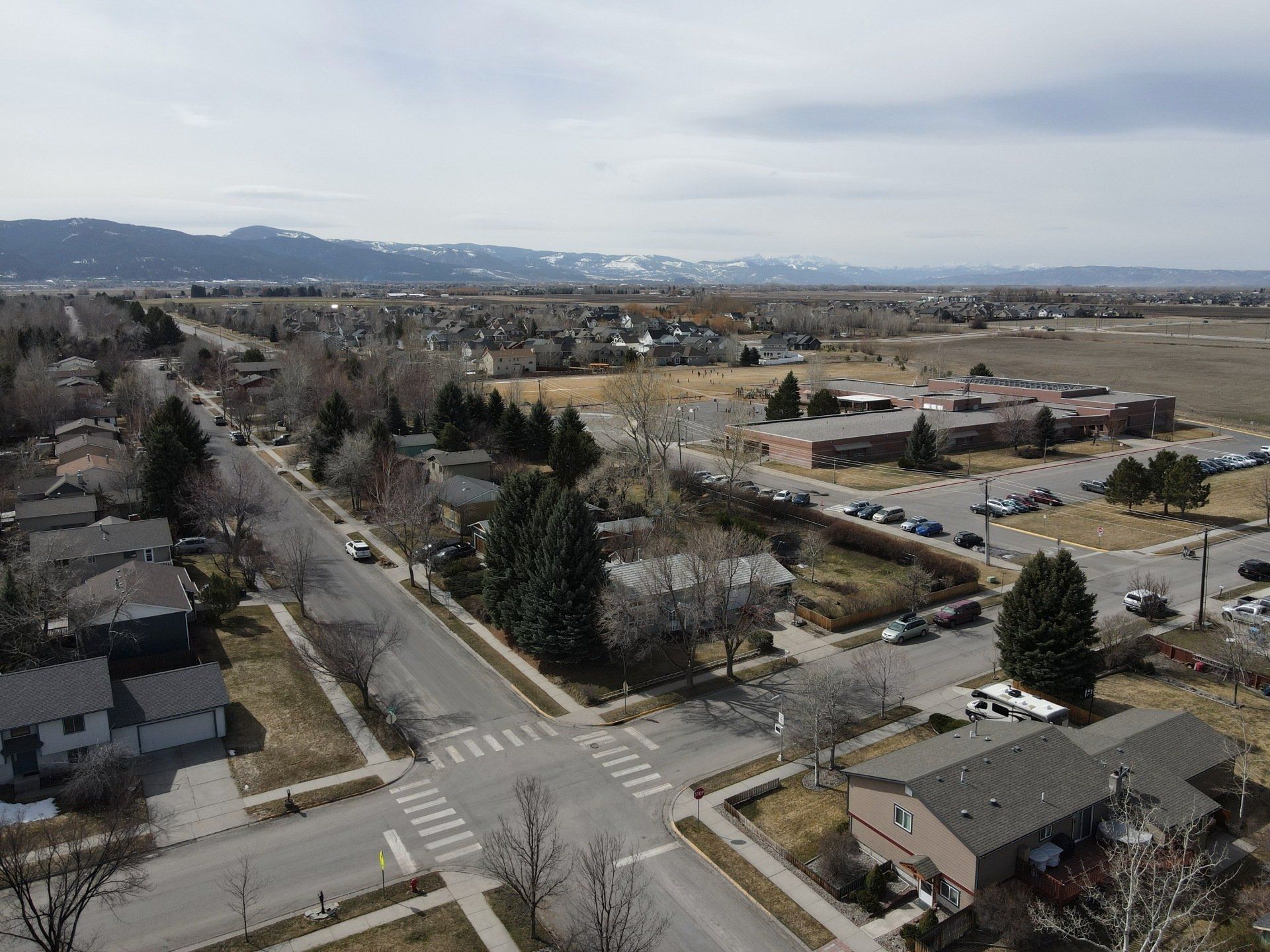 An aerial view of a residential neighborhood with mountains in the background.