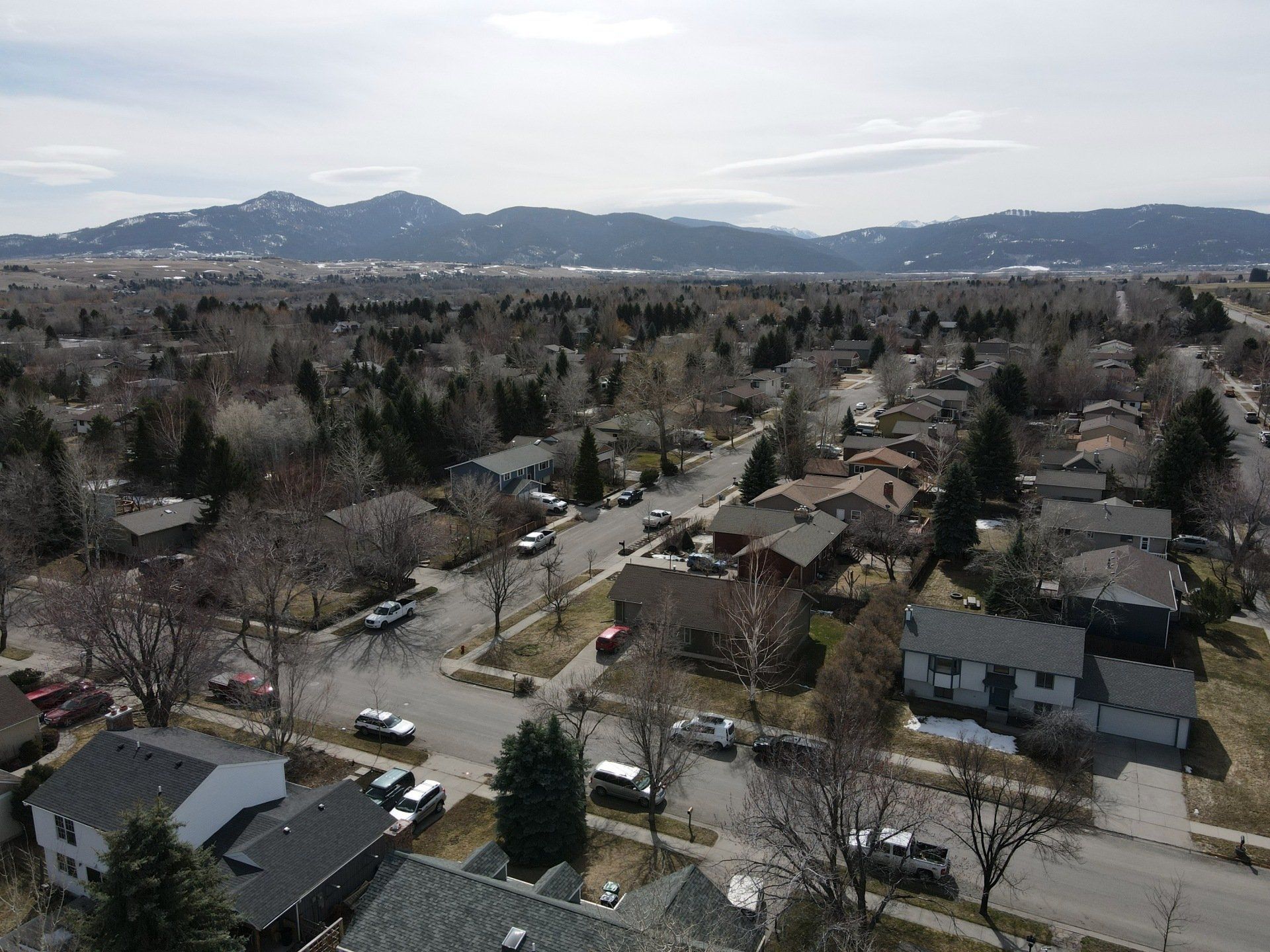 An aerial view of a residential neighborhood with mountains in the background.