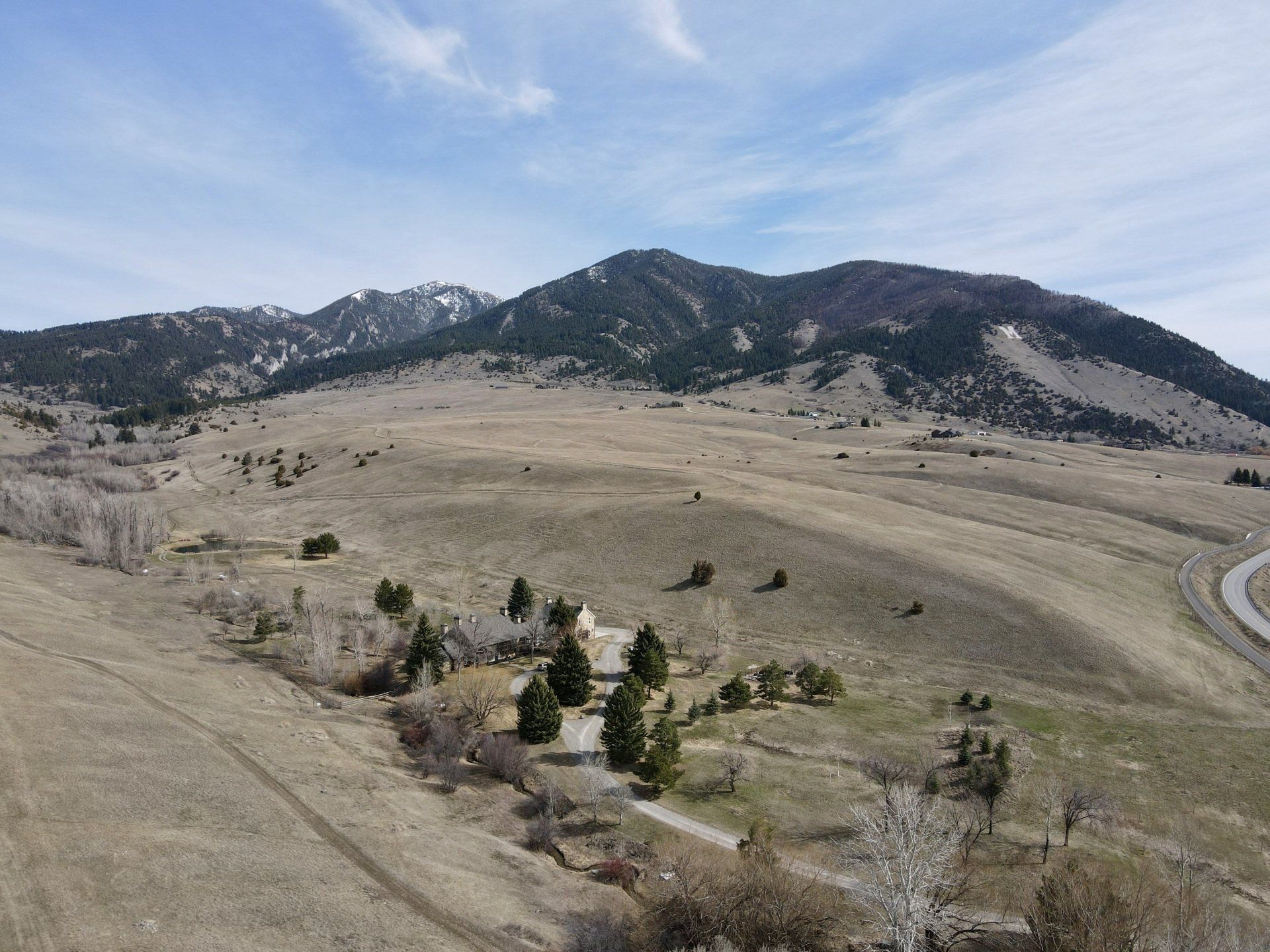 An aerial view of a valley with mountains in the background.