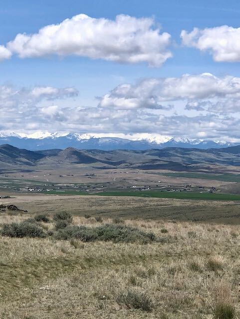large plains with mountains far off in the distance and clear blue sky