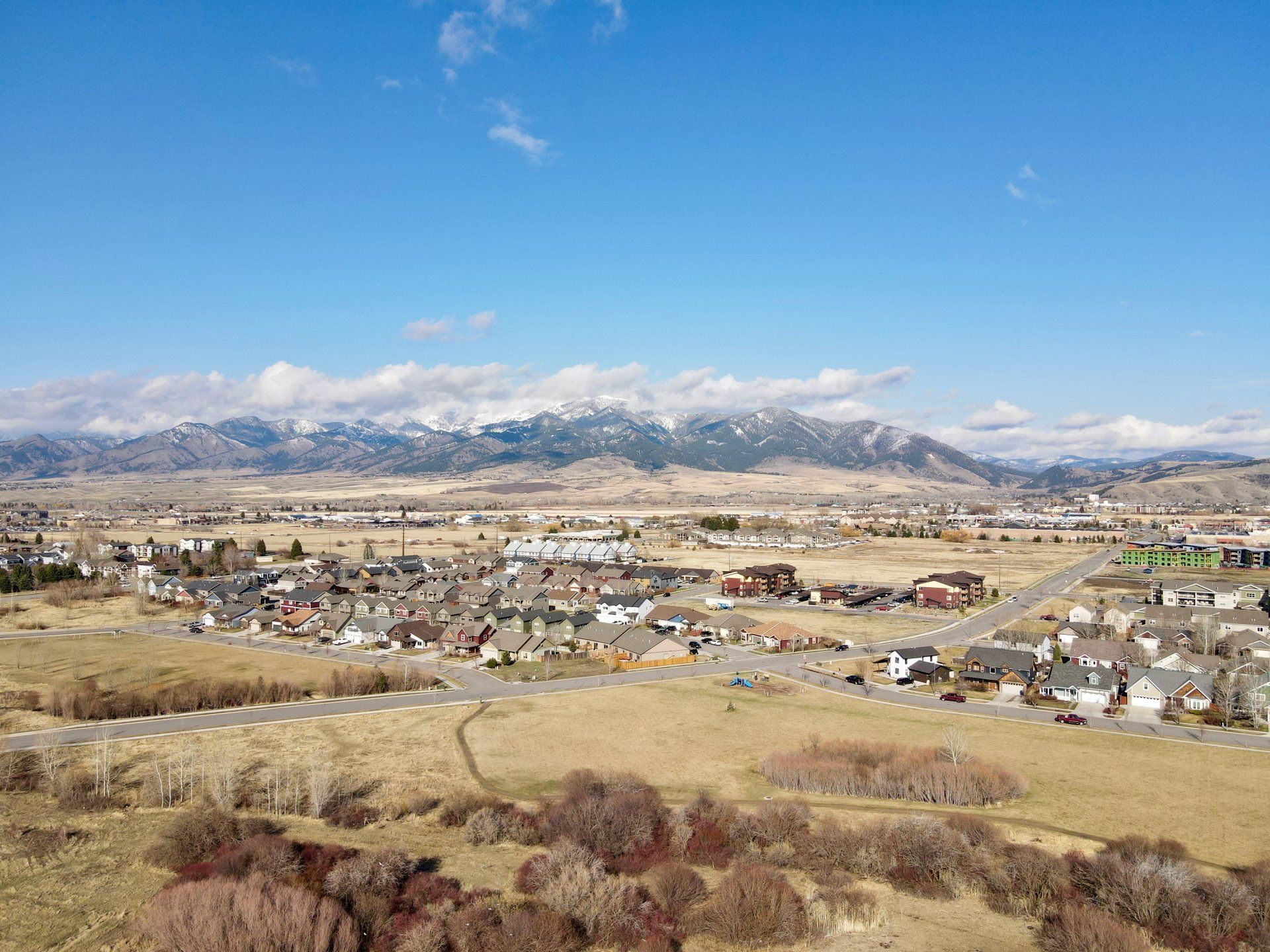 An aerial view of a small town with mountains in the background.
