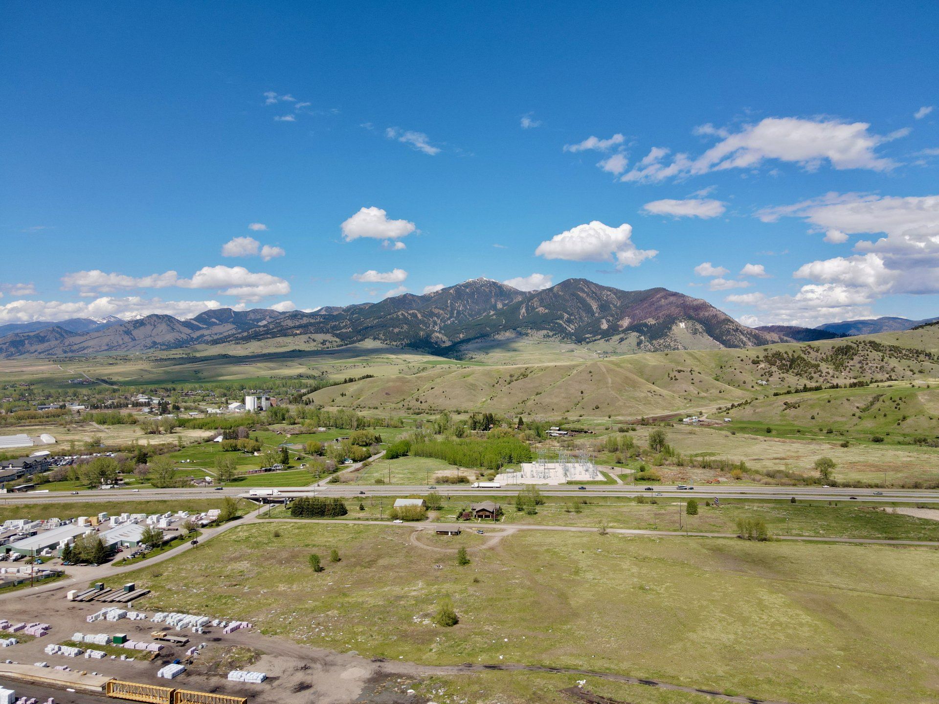 An aerial view of a valley with mountains in the background.
