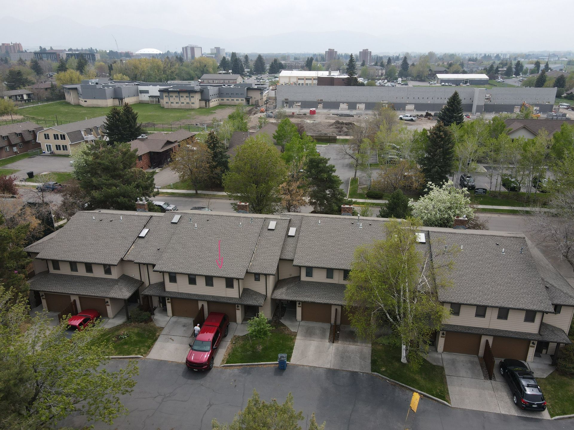 A red truck is parked in front of a row of houses