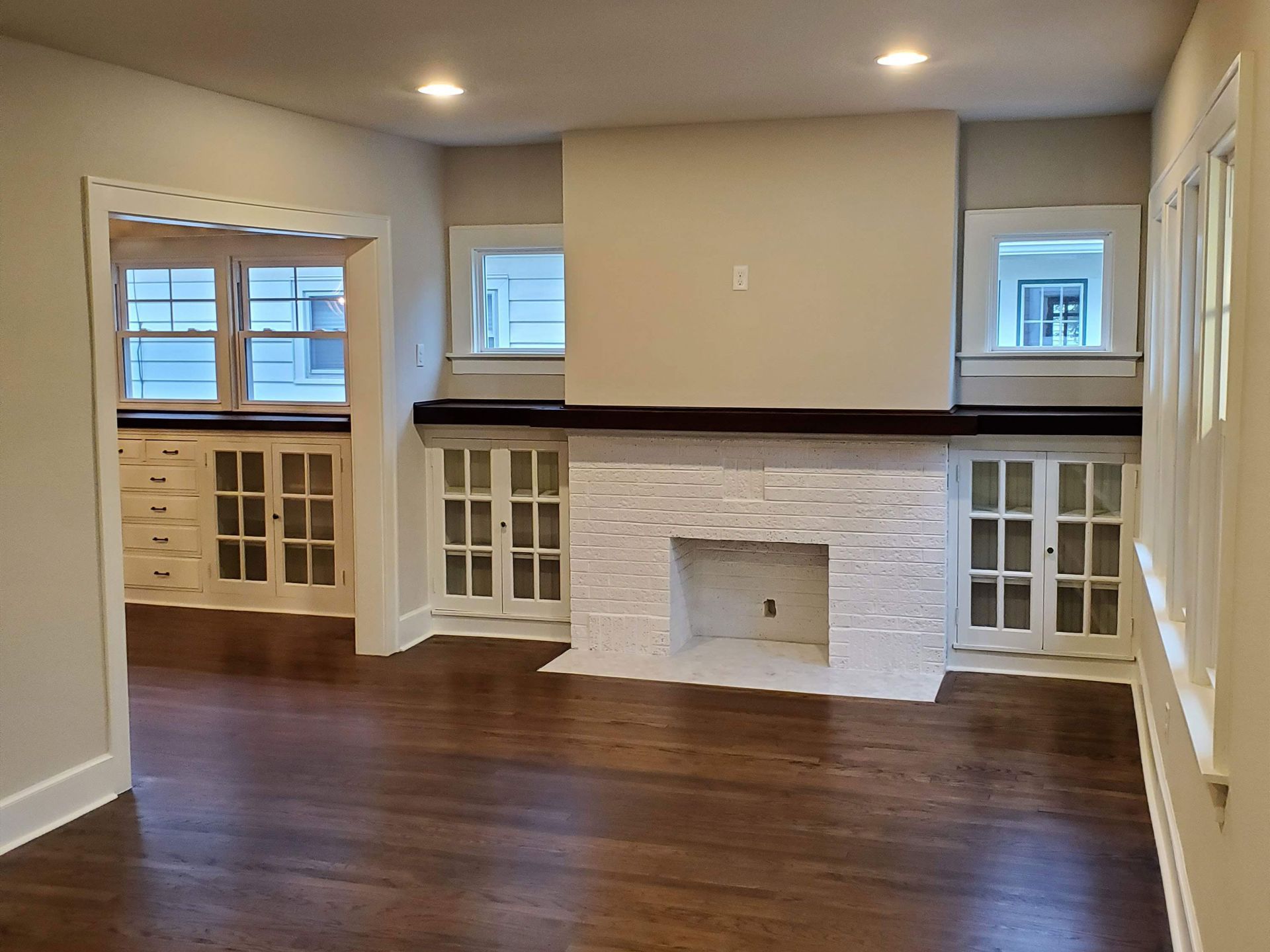 an empty living room with hardwood floors and a fireplace