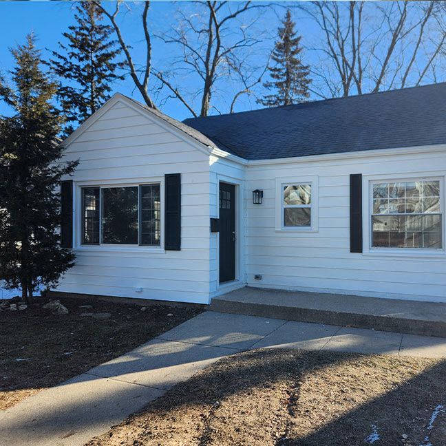 a white house with black shutters on the windows
