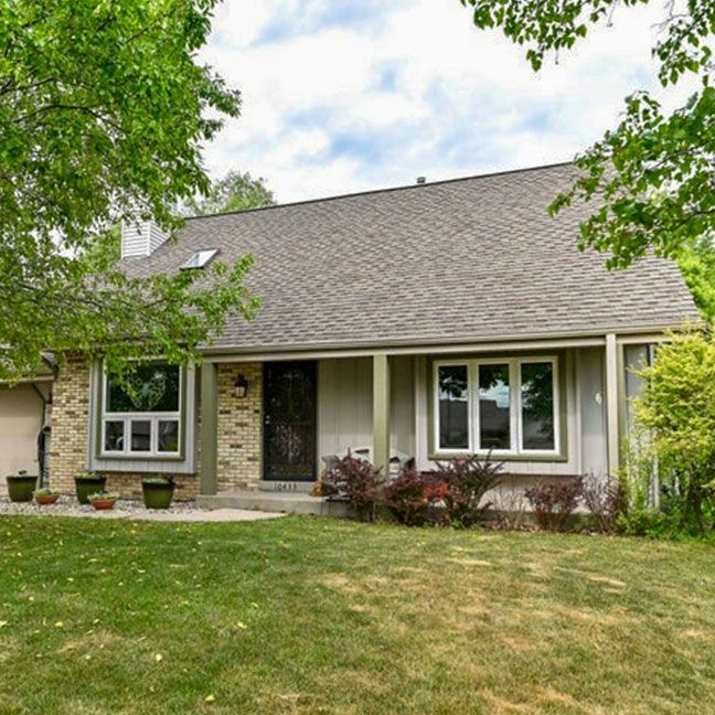 the front of a house with a porch and stairs