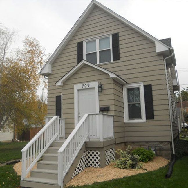 a large house with stairs leading up to the front door