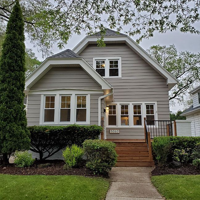 a house with a lot of windows and a walkway leading to it .