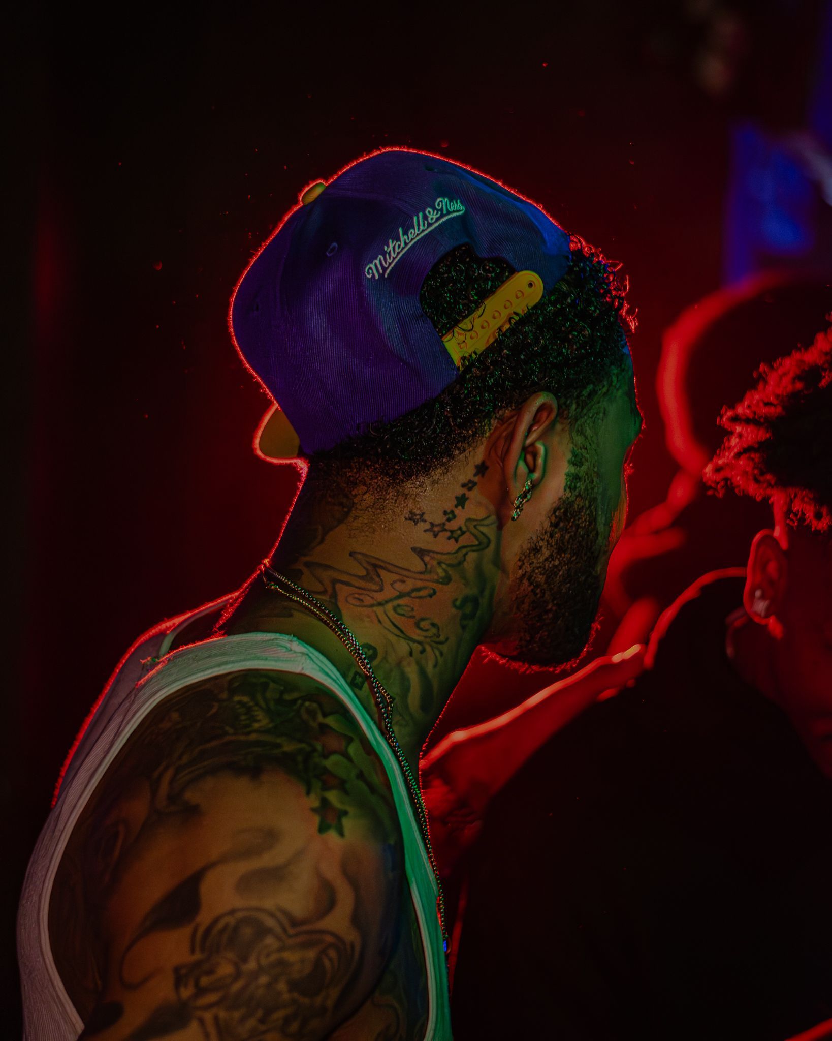 A man with tattoos on his arms and neck is wearing a purple hat. Trevion500