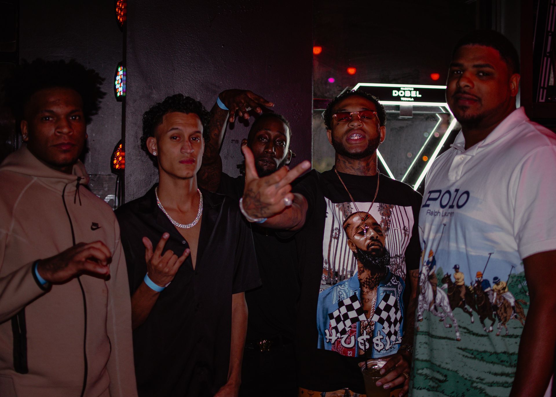 A group of young men are posing for a picture in a dark room. Trevion500