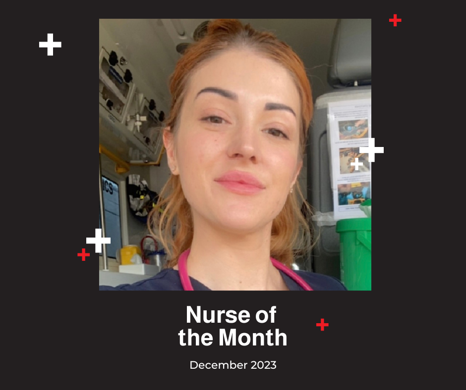 A nurse is standing in front of an ambulance.