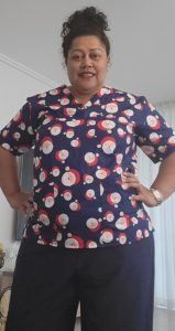 A woman is standing in a room with her hands on her hips.