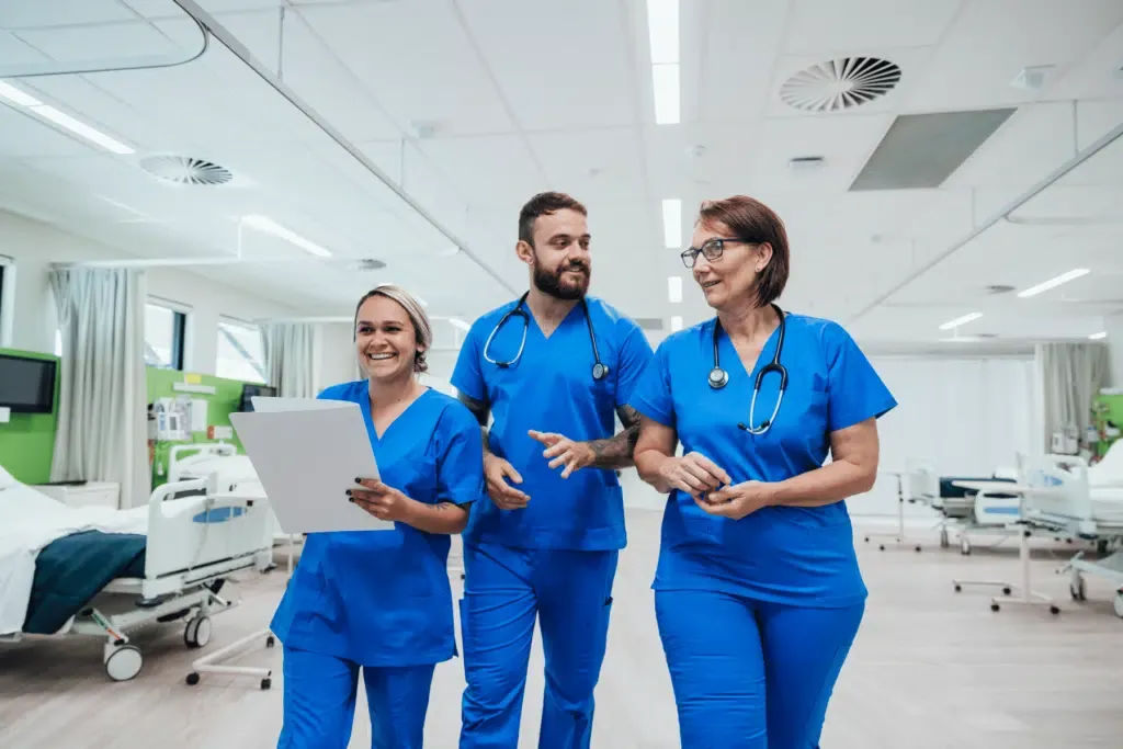 A group of nurses are walking down a hospital hallway.