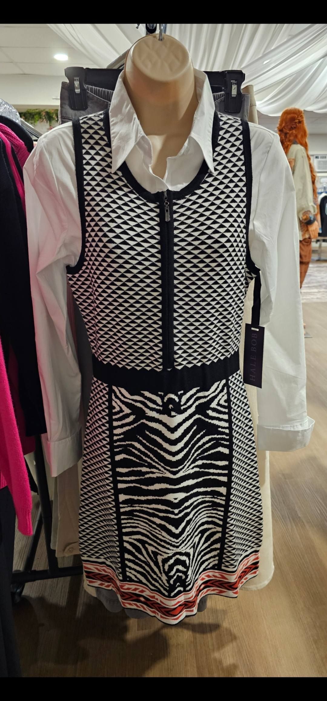 Mannequin wearing a white shirt under a black and white patterned zip-up dress with a zebra-print skirt.