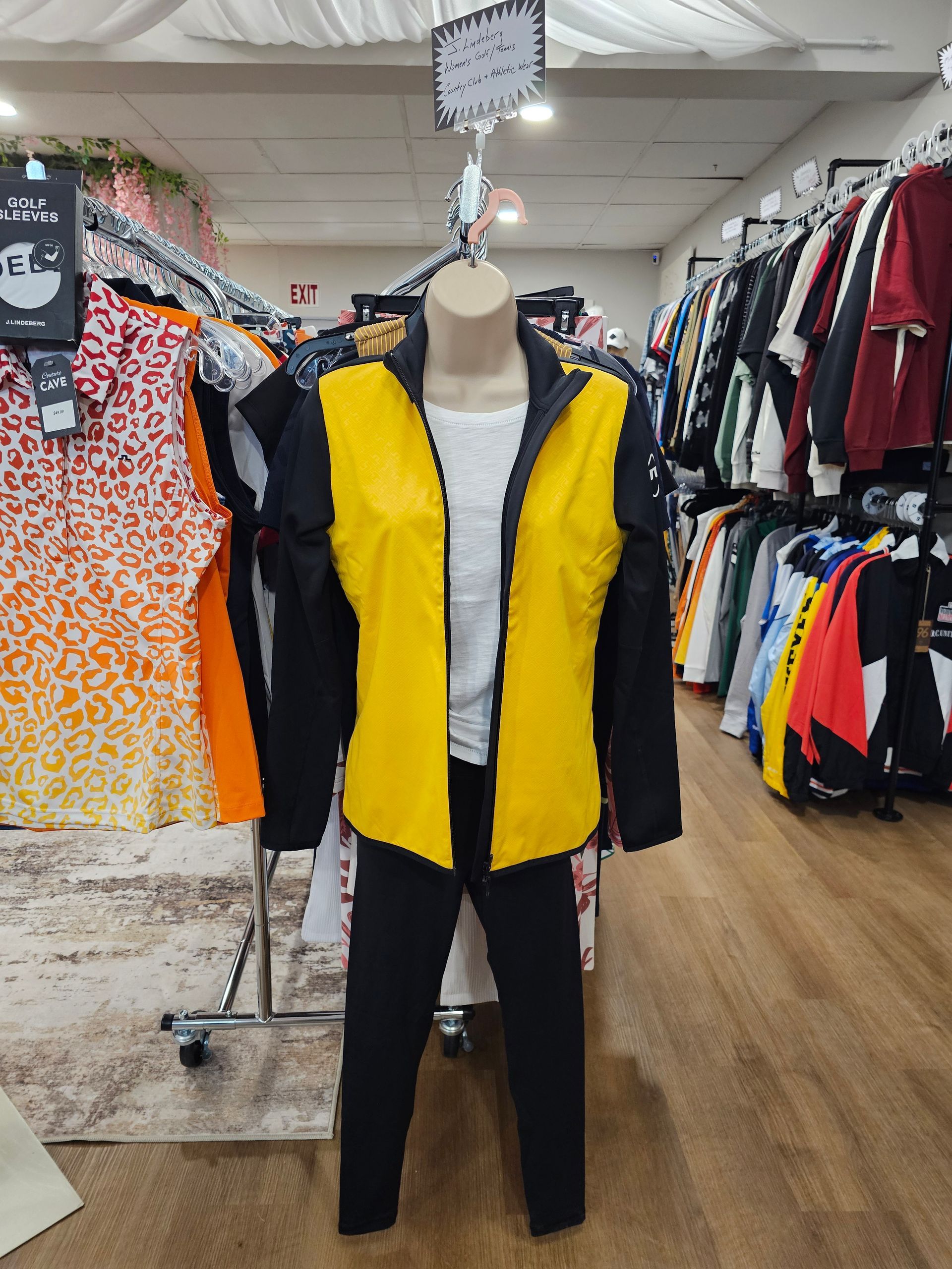 Couple on golf course in coats, holding clubs and bag.