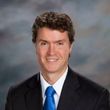 A man in a suit and tie is smiling for the camera.