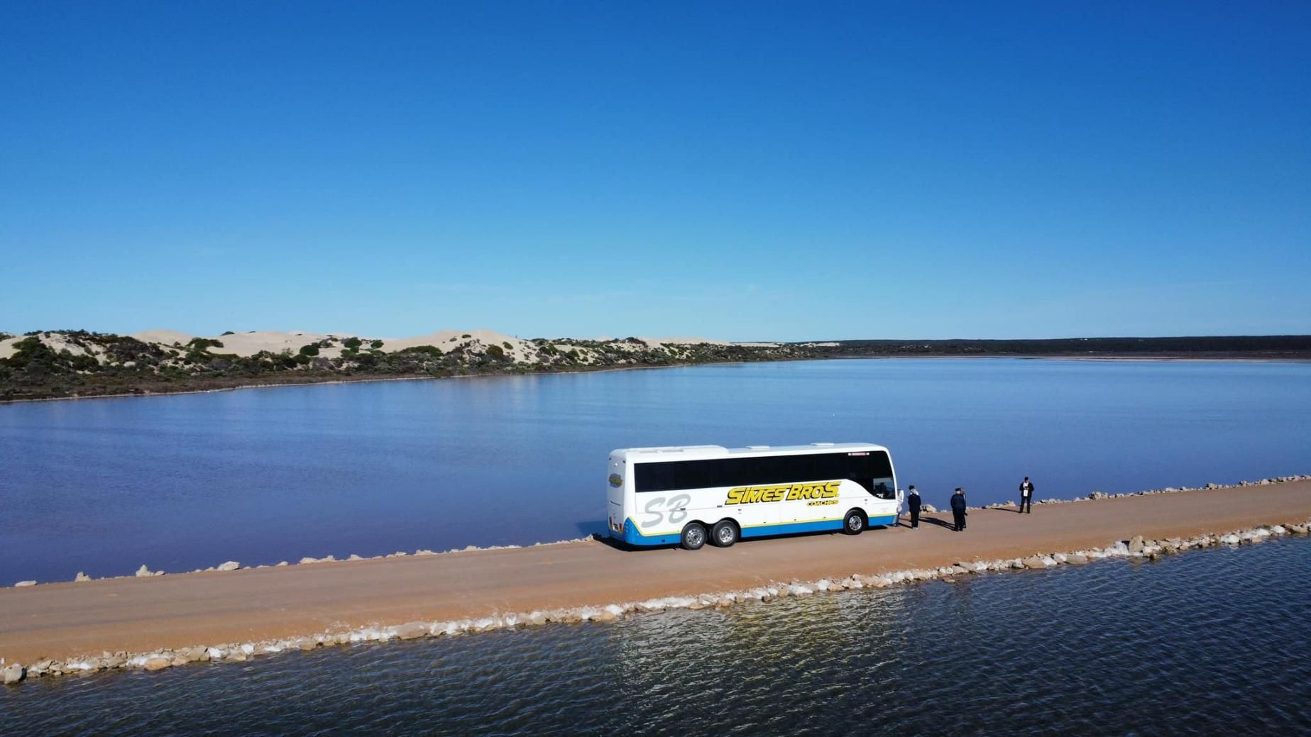 A Bus Is Parked on The Shore of A Lake — Simes Bros Coaches in South Lismore, NSW