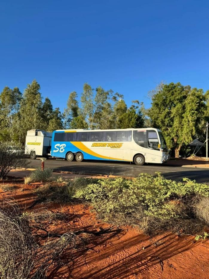 A Blue and Yellow Bus Is Parked on The Side of The Road — Simes Bros Coaches in South Lismore, NSW