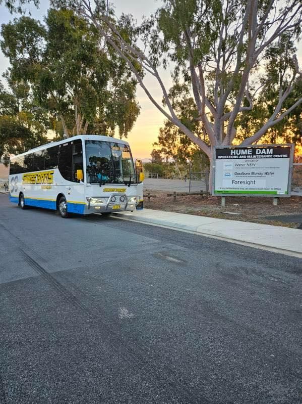 A White and Blue Bus Is Parked on The Side of The Road — Simes Bros Coaches in South Lismore, NSW