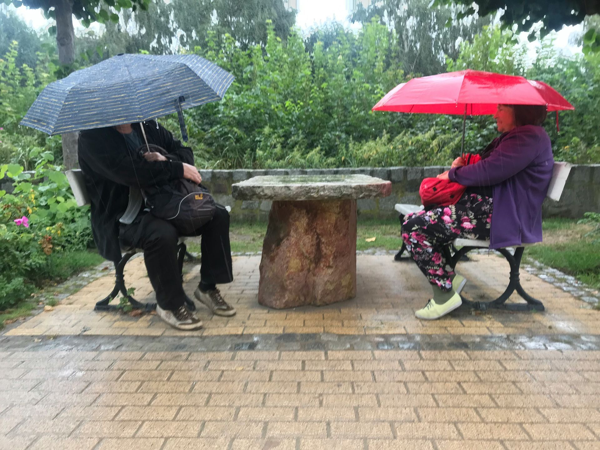 Two people facing each other, umbrellas symbolizing emotional distance and guarded connection.