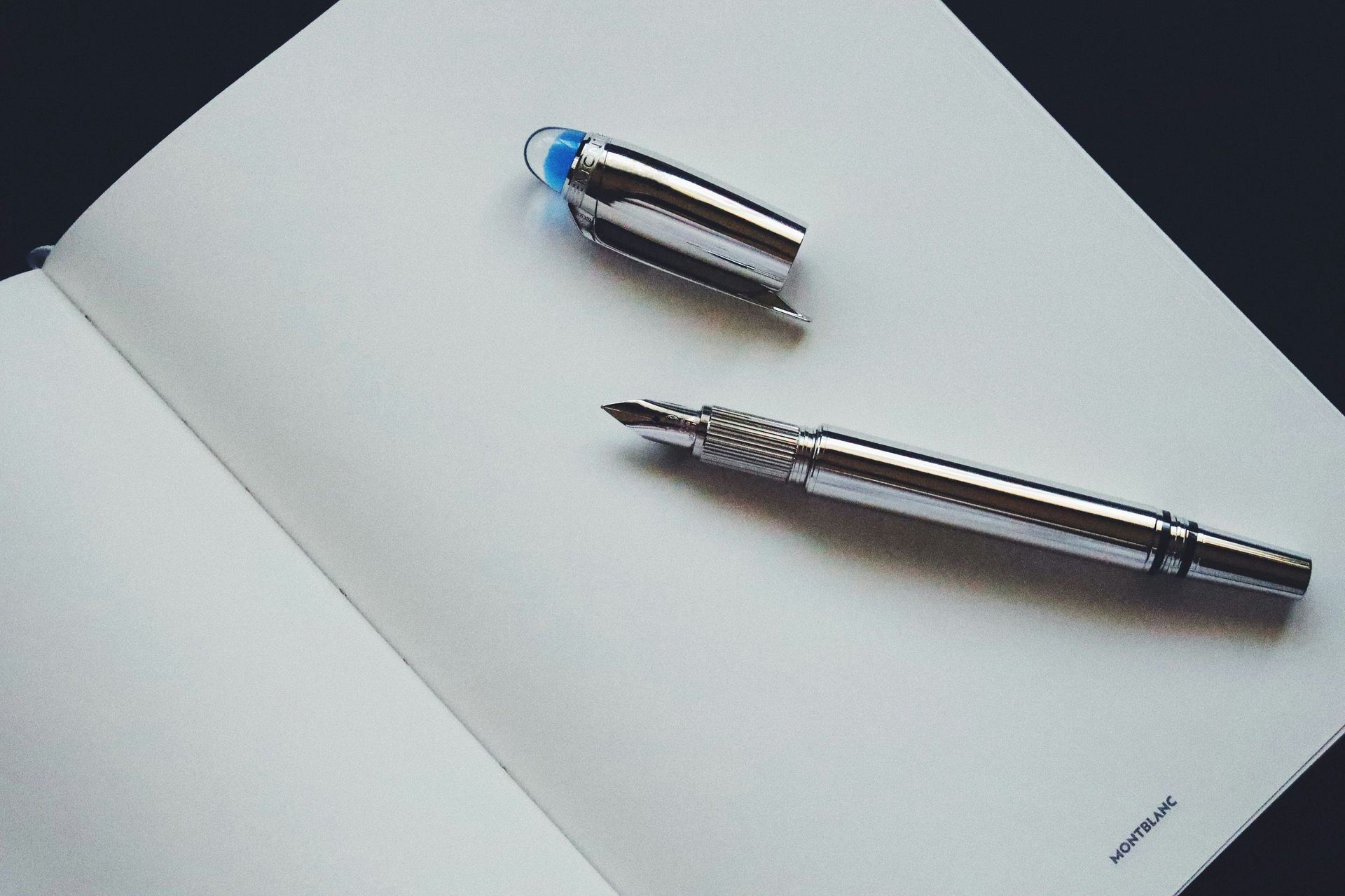 A silver pen on an open notebook symbolizes reflection and the start of a new life lesson.
