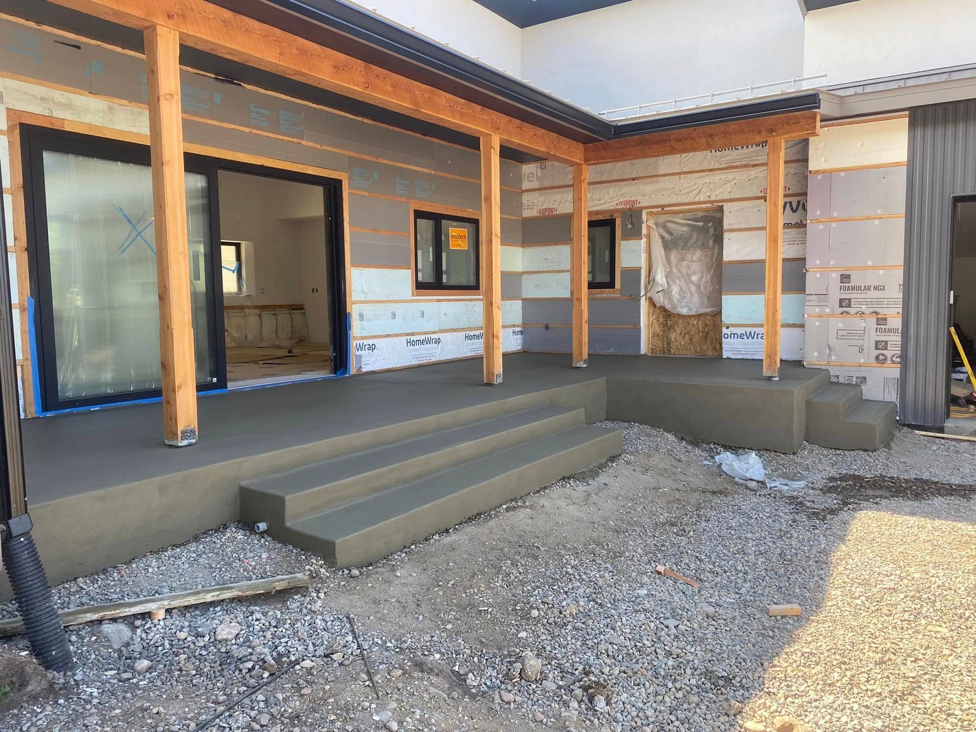 Modern house exterior with unfinished porch steps and gravel foreground
