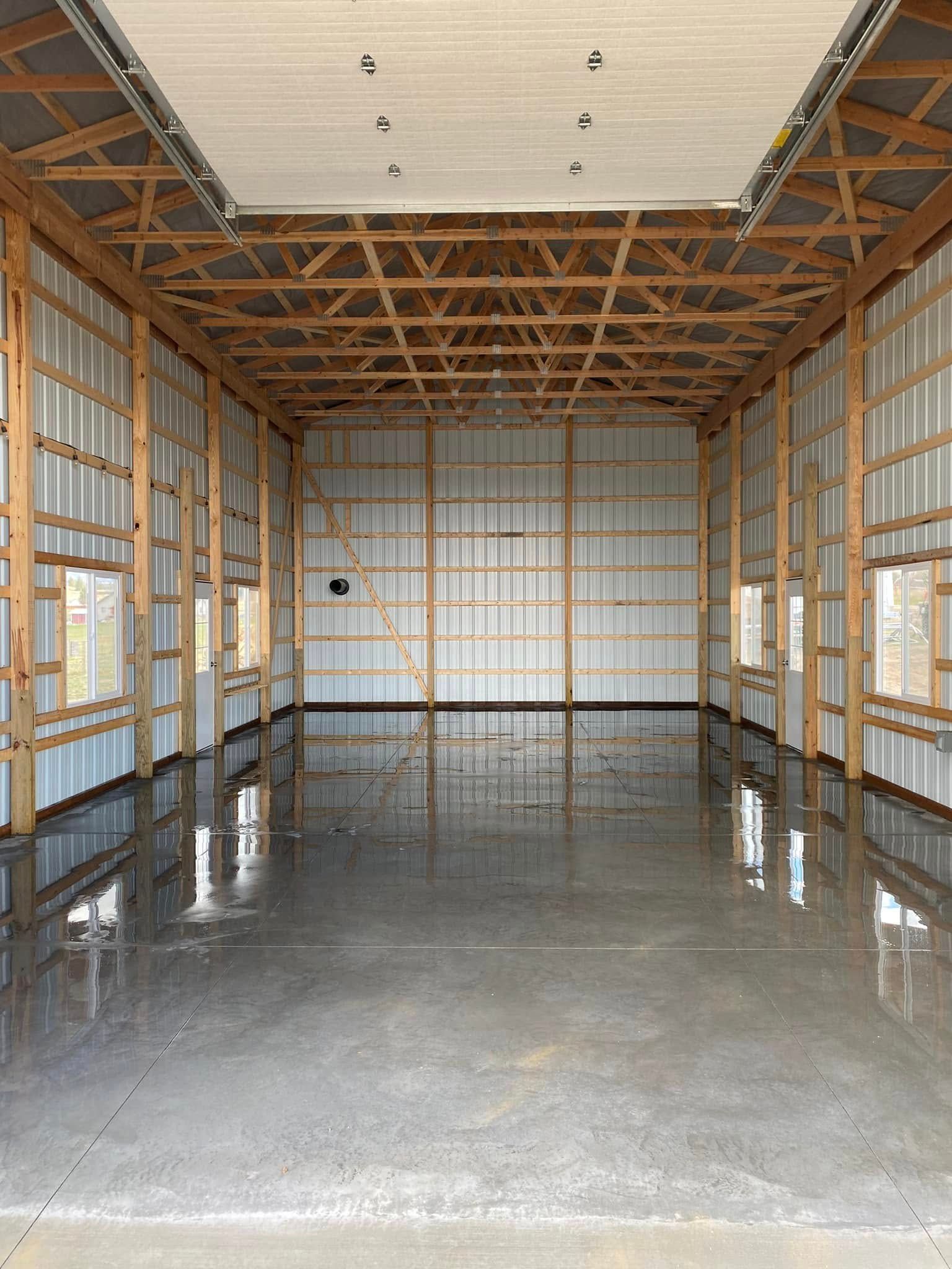 Empty construction interior with exposed wooden framing and a glossy concrete floor