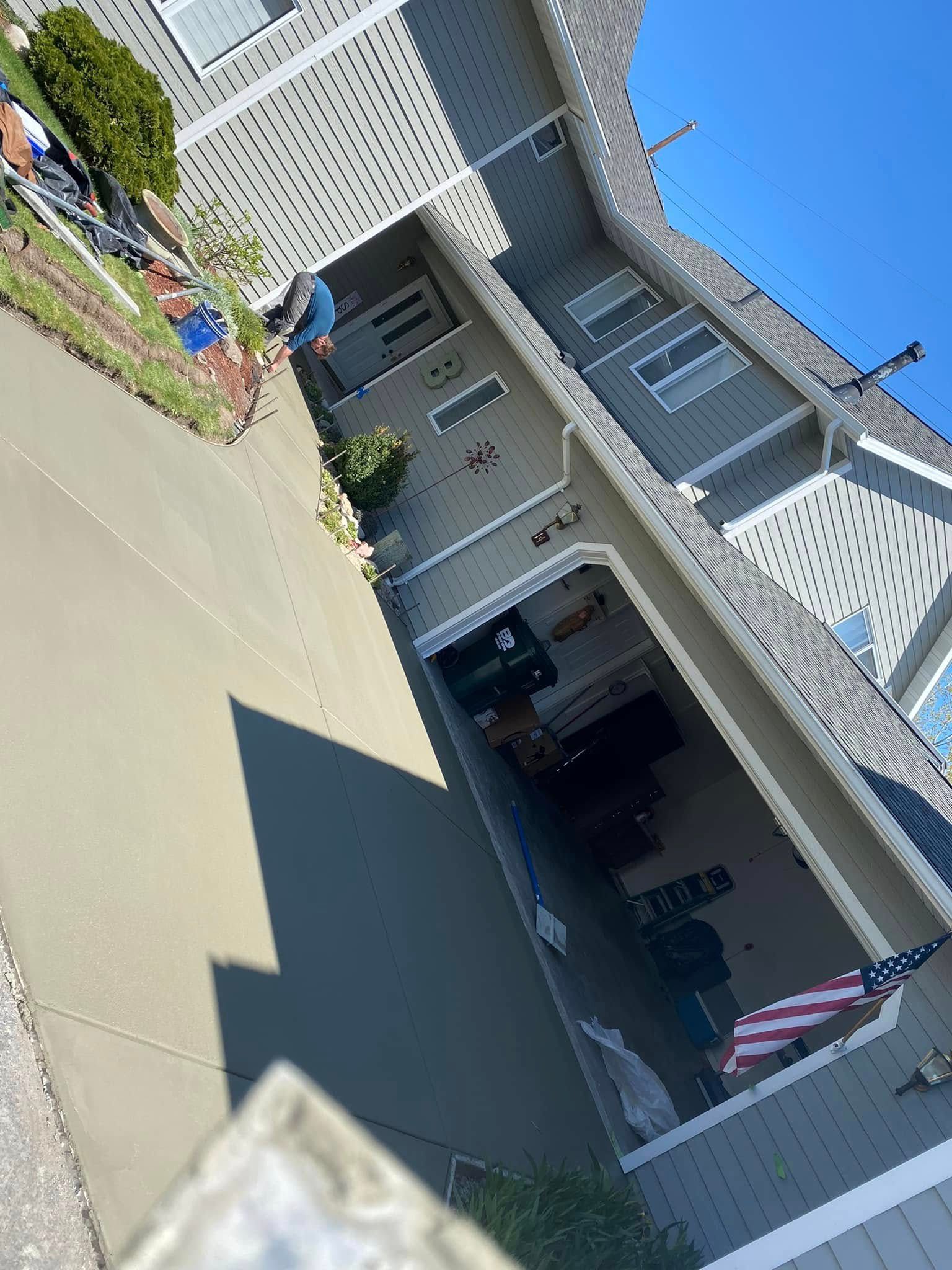 Tilted view of a house entrance with white trim, garage, and a large shadow across the driveway