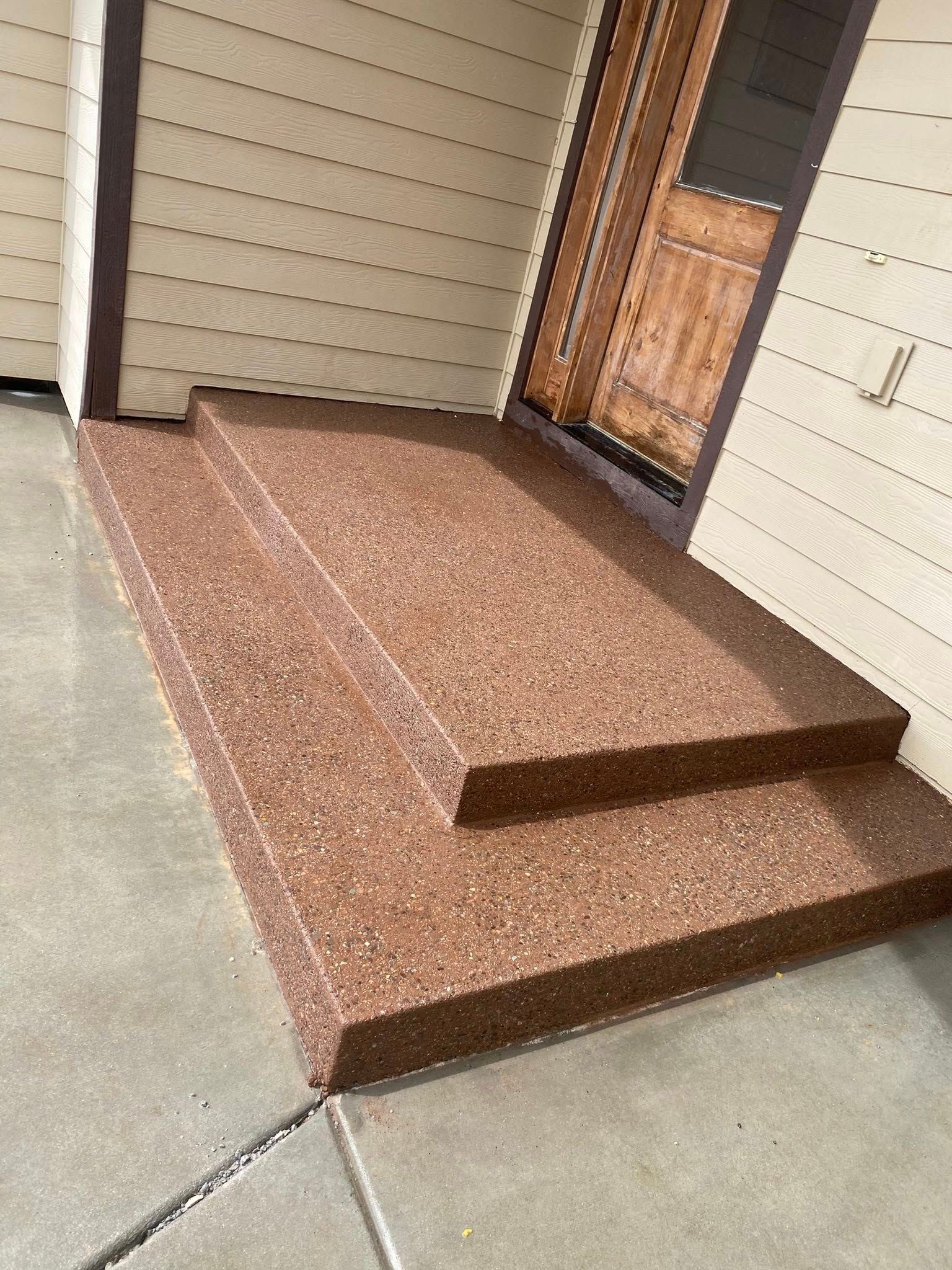 Front porch with brown tile steps leading to a wooden front door