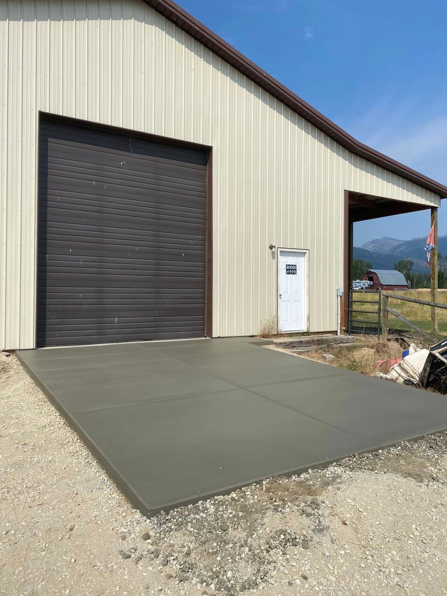 Industrial building with a closed roll-up door and a concrete apron outside.